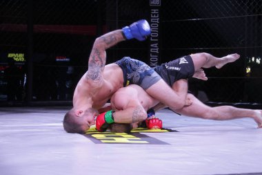 Odessa, Ukrayna-30 Haziran 2019: Mma boksörlerinin dövüşçüleri sekizgen kafes ringinde kuralsız dövüşüyorlar. Mma dövüşçüleri şampiyonada ringde