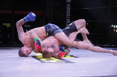 Odessa, Ukrayna-30 Haziran 2019: Mma boksörlerinin dövüşçüleri sekizgen kafes ringinde kuralsız dövüşüyorlar. Mma dövüşçüleri şampiyonada ringde