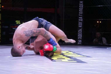 Odessa, Ukrayna-30 Haziran 2019: Mma boksörlerinin dövüşçüleri sekizgen kafes ringinde kuralsız dövüşüyorlar. Mma dövüşçüleri şampiyonada ringde