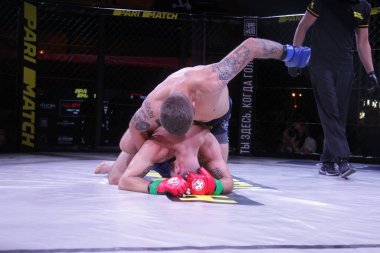 Odessa, Ukrayna-30 Haziran 2019: Mma boksörlerinin dövüşçüleri sekizgen kafes ringinde kuralsız dövüşüyorlar. Mma dövüşçüleri şampiyonada ringde