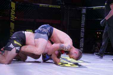 Odessa, Ukrayna-30 Haziran 2019: Mma boksörlerinin dövüşçüleri sekizgen kafes ringinde kuralsız dövüşüyorlar. Mma dövüşçüleri şampiyonada ringde