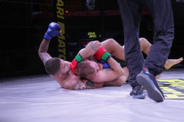 Odessa, Ukrayna-30 Haziran 2019: Mma boksörlerinin dövüşçüleri sekizgen kafes ringinde kuralsız dövüşüyorlar. Mma dövüşçüleri şampiyonada ringde