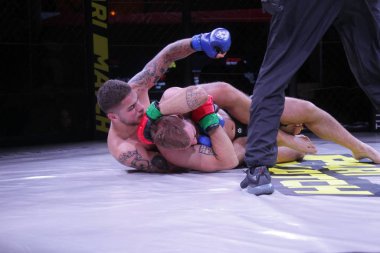 Odessa, Ukrayna-30 Haziran 2019: Mma boksörlerinin dövüşçüleri sekizgen kafes ringinde kuralsız dövüşüyorlar. Mma dövüşçüleri şampiyonada ringde