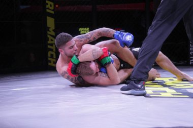 Odessa, Ukrayna-30 Haziran 2019: Mma boksörlerinin dövüşçüleri sekizgen kafes ringinde kuralsız dövüşüyorlar. Mma dövüşçüleri şampiyonada ringde