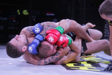 Odessa, Ukrayna-30 Haziran 2019: Mma boksörlerinin dövüşçüleri sekizgen kafes ringinde kuralsız dövüşüyorlar. Mma dövüşçüleri şampiyonada ringde
