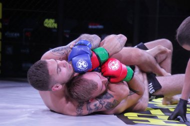 Odessa, Ukrayna-30 Haziran 2019: Mma boksörlerinin dövüşçüleri sekizgen kafes ringinde kuralsız dövüşüyorlar. Mma dövüşçüleri şampiyonada ringde