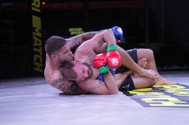 Odessa, Ukrayna-30 Haziran 2019: Mma boksörlerinin dövüşçüleri sekizgen kafes ringinde kuralsız dövüşüyorlar. Mma dövüşçüleri şampiyonada ringde