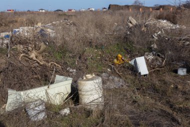 Doğada yasadışı çöplük. Bir açıklıktaki yasadışı bir çöplükte inşaat ve ev çöpü. Vahşi yaşamın cezai çevre kirliliği