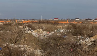 Doğada yasadışı çöplük. Bir açıklıktaki yasadışı bir çöplükte inşaat ve ev çöpü. Vahşi yaşamın cezai çevre kirliliği