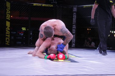 Odessa, Ukrayna-Haziran 30, 2019: Mma boksörler Fighters sekizgenkafes halka kuralları olmadan mücadele ediyor. Mma dövüşçüleri şampiyonada ringde. Metal kafes ten kuralsız boks kavgaları bak