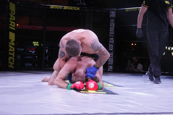 Odessa, Ukrayna-Haziran 30, 2019: Mma boksörler Fighters sekizgenkafes halka kuralları olmadan mücadele ediyor. Mma dövüşçüleri şampiyonada ringde. Metal kafes ten kuralsız boks kavgaları bak