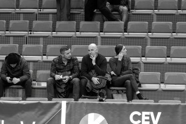 ODESSA, UKRAINE - CIRKA FEBRUARY, 2020: Spectators in stands of gym during game of their favorite teams. Sports fans and spectators in stadium racks emotionally support their team