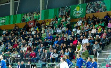 ODESSA, UKRAINE - CIRKA FEBRUARY, 2020: Spectators in stands of gym during game of their favorite teams. Sports fans and spectators in stadium racks emotionally support their team