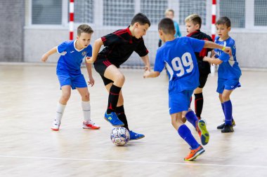 Odessa, Ukrayna-12 Aralık 2019: Küçük çocuklar ve çocuklar spor salonunda küçükler şampiyonasında mini futbol oynuyorlar. Çocuk sporu sağlıklı bir yaşam tarzıdır. Sporcu çocuklar futbol oyuncuları