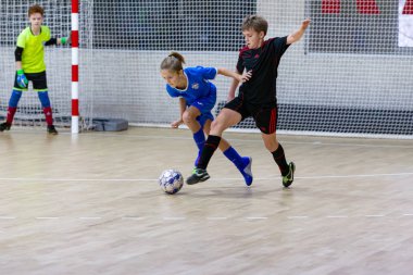 Odessa, Ukrayna-12 Aralık 2019: Küçük çocuklar ve çocuklar spor salonunda küçükler şampiyonasında mini futbol oynuyorlar. Çocuk sporu sağlıklı bir yaşam tarzıdır. Sporcu çocuklar futbol oyuncuları