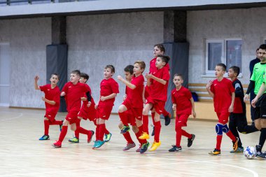 Odessa, Ukrayna-12 Aralık 2019: Küçük çocuklar ve çocuklar spor salonunda küçükler şampiyonasında mini futbol oynuyorlar. Çocuk sporu sağlıklı bir yaşam tarzıdır. Sporcu çocuklar futbol oyuncuları