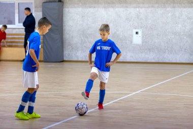 Odessa, Ukrayna-12 Aralık 2019: Küçük çocuklar ve çocuklar spor salonunda küçükler şampiyonasında mini futbol oynuyorlar. Çocuk sporu sağlıklı bir yaşam tarzıdır. Sporcu çocuklar futbol oyuncuları