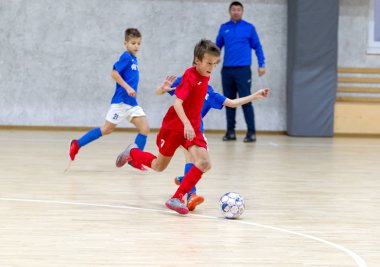 Odessa, Ukrayna-12 Aralık 2019: Küçük çocuklar ve çocuklar spor salonunda küçükler şampiyonasında mini futbol oynuyorlar. Çocuk sporu sağlıklı bir yaşam tarzıdır. Sporcu çocuklar futbol oyuncuları