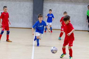 Odessa, Ukrayna-12 Aralık 2019: Küçük çocuklar ve çocuklar spor salonunda küçükler şampiyonasında mini futbol oynuyorlar. Çocuk sporu sağlıklı bir yaşam tarzıdır. Sporcu çocuklar futbol oyuncuları