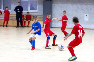 Odessa, Ukrayna-12 Aralık 2019: Küçük çocuklar ve çocuklar spor salonunda küçükler şampiyonasında mini futbol oynuyorlar. Çocuk sporu sağlıklı bir yaşam tarzıdır. Sporcu çocuklar futbol oyuncuları
