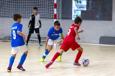 Odessa, Ukrayna-12 Aralık 2019: Küçük çocuklar ve çocuklar spor salonunda küçükler şampiyonasında mini futbol oynuyorlar. Çocuk sporu sağlıklı bir yaşam tarzıdır. Sporcu çocuklar futbol oyuncuları