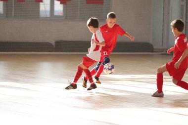 Odessa, Ukrayna-12 Aralık 2019: Küçük çocuklar ve çocuklar spor salonunda küçükler şampiyonasında mini futbol oynuyorlar. Çocuk sporu sağlıklı bir yaşam tarzıdır. Sporcu çocuklar futbol oyuncuları