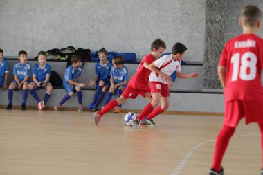 Odessa, Ukrayna-12 Aralık 2019: Küçük çocuklar ve çocuklar spor salonunda küçükler şampiyonasında mini futbol oynuyorlar. Çocuk sporu sağlıklı bir yaşam tarzıdır. Sporcu çocuklar futbol oyuncuları