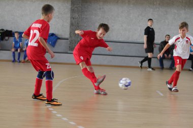 Odessa, Ukrayna-12 Aralık 2019: Küçük çocuklar ve çocuklar spor salonunda küçükler şampiyonasında mini futbol oynuyorlar. Çocuk sporu sağlıklı bir yaşam tarzıdır. Sporcu çocuklar futbol oyuncuları