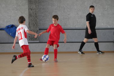 Odessa, Ukrayna-12 Aralık 2019: Küçük çocuklar ve çocuklar spor salonunda küçükler şampiyonasında mini futbol oynuyorlar. Çocuk sporu sağlıklı bir yaşam tarzıdır. Sporcu çocuklar futbol oyuncuları