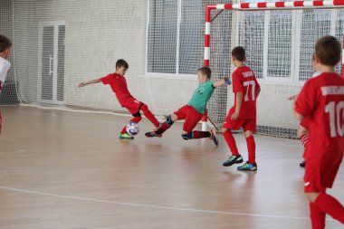 Odessa, Ukrayna-12 Aralık 2019: Küçük çocuklar ve çocuklar spor salonunda küçükler şampiyonasında mini futbol oynuyorlar. Çocuk sporu sağlıklı bir yaşam tarzıdır. Sporcu çocuklar futbol oyuncuları