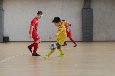 Odessa, Ukrayna-12 Aralık 2019: Küçük çocuklar ve çocuklar spor salonunda küçükler şampiyonasında mini futbol oynuyorlar. Çocuk sporu sağlıklı bir yaşam tarzıdır. Sporcu çocuklar futbol oyuncuları