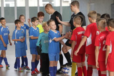 Odessa, Ukrayna-12 Aralık 2019: Küçük çocuklar ve çocuklar spor salonunda küçükler şampiyonasında mini futbol oynuyorlar. Çocuk sporu sağlıklı bir yaşam tarzıdır. Sporcu çocuklar futbol oyuncuları