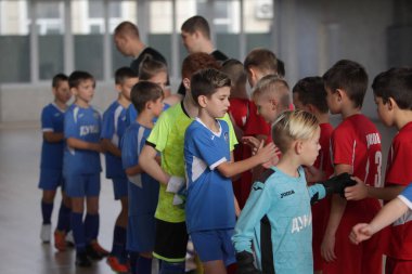 Odessa, Ukrayna-12 Aralık 2019: Küçük çocuklar ve çocuklar spor salonunda küçükler şampiyonasında mini futbol oynuyorlar. Çocuk sporu sağlıklı bir yaşam tarzıdır. Sporcu çocuklar futbol oyuncuları