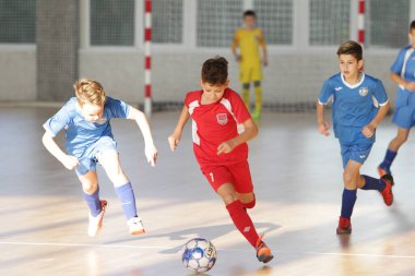 Odessa, Ukrayna-12 Aralık 2019: Küçük çocuklar ve çocuklar spor salonunda küçükler şampiyonasında mini futbol oynuyorlar. Çocuk sporu sağlıklı bir yaşam tarzıdır. Sporcu çocuklar futbol oyuncuları