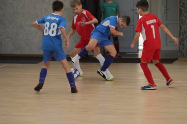 Odessa, Ukrayna-12 Aralık 2019: Küçük çocuklar ve çocuklar spor salonunda küçükler şampiyonasında mini futbol oynuyorlar. Çocuk sporu sağlıklı bir yaşam tarzıdır. Sporcu çocuklar futbol oyuncuları