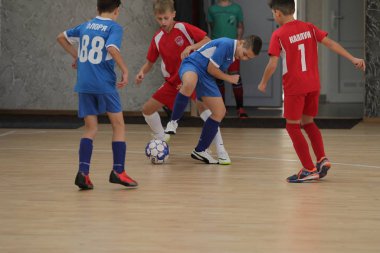Odessa, Ukrayna-12 Aralık 2019: Küçük çocuklar ve çocuklar spor salonunda küçükler şampiyonasında mini futbol oynuyorlar. Çocuk sporu sağlıklı bir yaşam tarzıdır. Sporcu çocuklar futbol oyuncuları