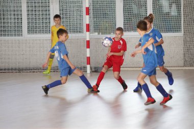 Odessa, Ukrayna-12 Aralık 2019: Küçük çocuklar ve çocuklar spor salonunda küçükler şampiyonasında mini futbol oynuyorlar. Çocuk sporu sağlıklı bir yaşam tarzıdır. Sporcu çocuklar futbol oyuncuları