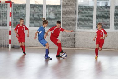 Odessa, Ukrayna-12 Aralık 2019: Küçük çocuklar ve çocuklar spor salonunda küçükler şampiyonasında mini futbol oynuyorlar. Çocuk sporu sağlıklı bir yaşam tarzıdır. Sporcu çocuklar futbol oyuncuları