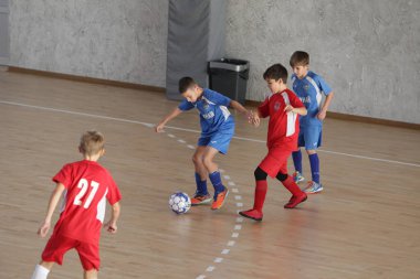 Odessa, Ukrayna-12 Aralık 2019: Küçük çocuklar ve çocuklar spor salonunda küçükler şampiyonasında mini futbol oynuyorlar. Çocuk sporu sağlıklı bir yaşam tarzıdır. Sporcu çocuklar futbol oyuncuları