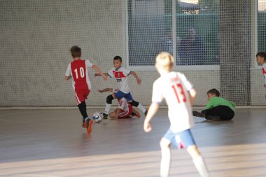 Odessa, Ukrayna-12 Aralık 2019: Küçük çocuklar ve çocuklar spor salonunda küçükler şampiyonasında mini futbol oynuyorlar. Çocuk sporu sağlıklı bir yaşam tarzıdır. Sporcu çocuklar futbol oyuncuları