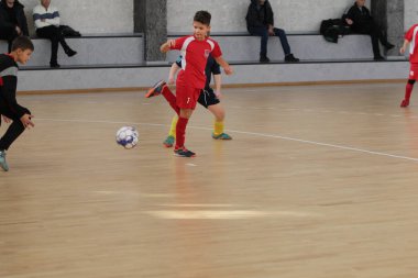 Odessa, Ukrayna-12 Aralık 2019: Küçük çocuklar ve çocuklar spor salonunda küçükler şampiyonasında mini futbol oynuyorlar. Çocuk sporu sağlıklı bir yaşam tarzıdır. Sporcu çocuklar futbol oyuncuları