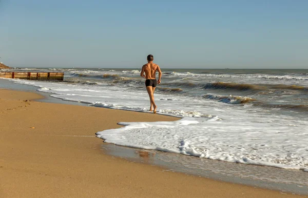 A soft sea wave rolls onto the sand of the beach. Seascape waves on the coast