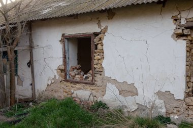 Pencereleri ve duvarları harap olmuş terk edilmiş eski bir bina. Eski tuğla duvarda kocaman çatlaklar var. Terk edilmiş eve gerek yok. Deprem üstüne yıkım. Kıyamet