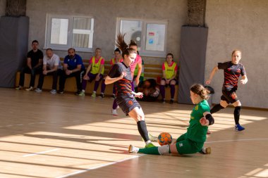ODESSA, UKRAINE - March 13, 2020: Futsal Cup of Ukraine, futsal among students. During final match in futsal among student teams. Beautiful sports girls play mini football on parquet floor