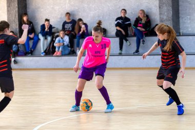 ODESSA, UKRAINE - March 13, 2020: Futsal Cup of Ukraine, futsal among students. During final match in futsal among student teams. Beautiful sports girls play mini football on parquet floor