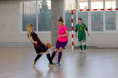 ODESSA, UKRAINE - March 13, 2020: Futsal Cup of Ukraine, futsal among students. During final match in futsal among student teams. Beautiful sports girls play mini football on parquet floor