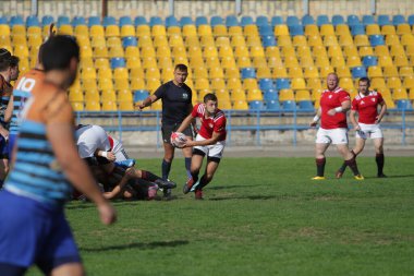 ODESSA, UKRAINE - SEPT 20, 2017: CREDO-Odessa Rugby Şampiyonası Milli Takımı - Politeknik-Kiev. Rugby oyuncularının top için yoğun mücadelesi. Stadyumun yeşil sahasında dinamik oyun