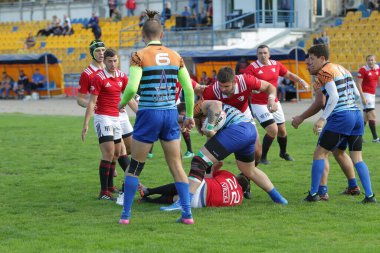 ODESSA, UKRAINE - SEPT 20, 2017: CREDO-Odessa Rugby Şampiyonası Milli Takımı - Politeknik-Kiev. Rugby oyuncularının top için yoğun mücadelesi. Stadyumun yeşil sahasında dinamik oyun