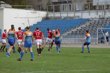 ODESSA, UKRAINE - SEPT 20, 2017: CREDO-Odessa Rugby Şampiyonası Milli Takımı - Politeknik-Kiev. Rugby oyuncularının top için yoğun mücadelesi. Stadyumun yeşil sahasında dinamik oyun