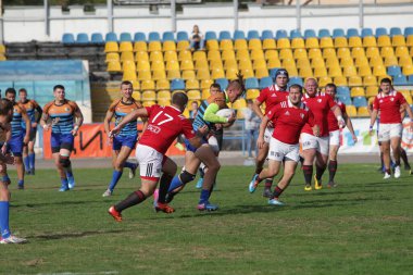 ODESSA, UKRAINE - SEPT 20, 2017: CREDO-Odessa Rugby Şampiyonası Milli Takımı - Politeknik-Kiev. Rugby oyuncularının top için yoğun mücadelesi. Stadyumun yeşil sahasında dinamik oyun
